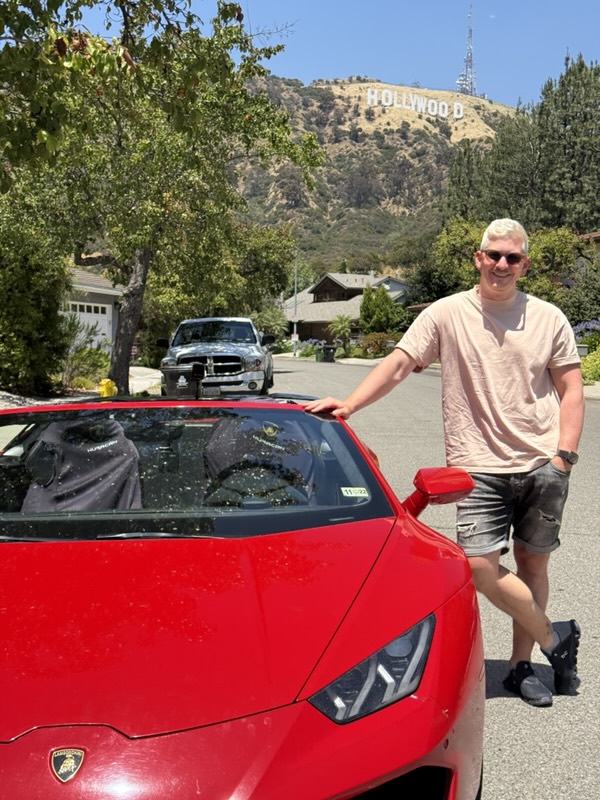 Neben dem Lamborghini mit dem Hollywood Sign im Hintergrund